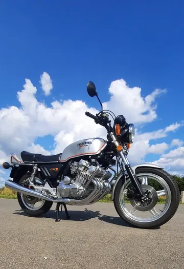 Stříbrná Honda CBX 1000 na silnici pod modrou oblohou s mraky