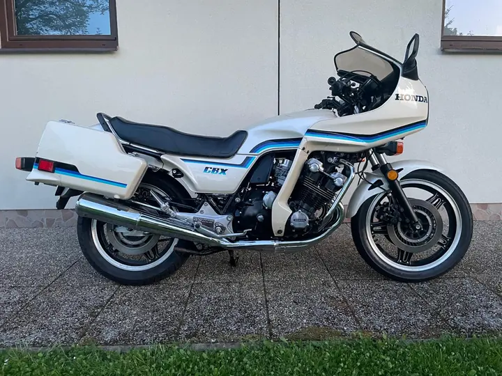 Bílá Honda CBX 1000 s modrým pruhem před světlou zdí