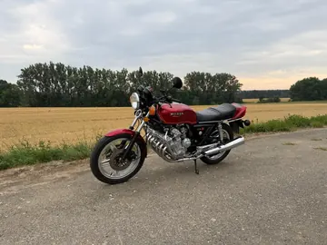 Červená Honda CBX 1000 na okraji pole za soumraku