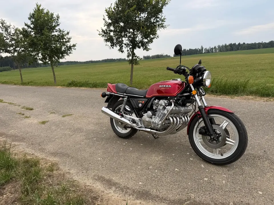 Červená Honda CBX 1000 na polní cestě u zelené louky