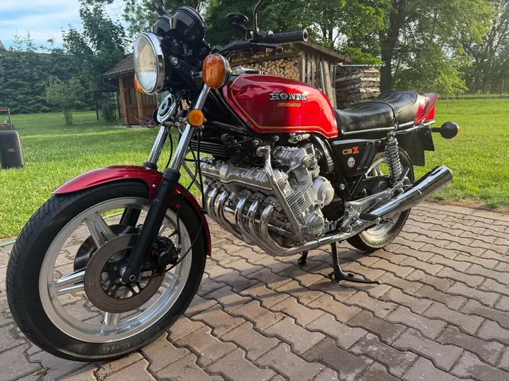 Červená Honda CBX 1000 zepředu, v pozadí dřevěný přístřešek